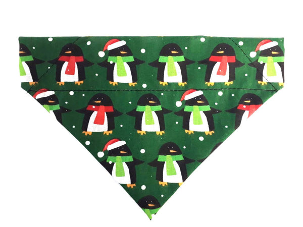 Penguin Christmas bandana for dogs with Santa hats on a green snowy background.